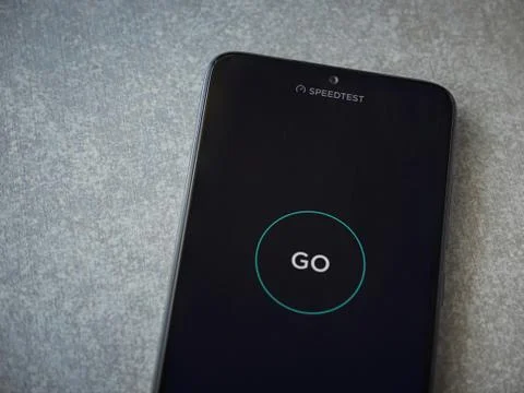 Speedtest app launch screen with logo on the display of a black mobile smartp Stock Photos