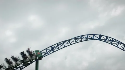 Speedy rollercoaster attraction. People riding rollercoaster upside down Stock Footage 196156353