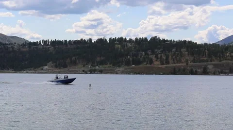 Speetboat Passing Left to Right on Mountainside Lake Stock Footage 52307341