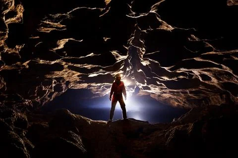 Speleologist in a cave in the rays of light Stock Photos