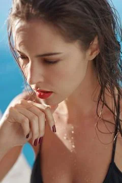 Spending her summer out by the pool. a young woman at a swimming pool. Stock Photos