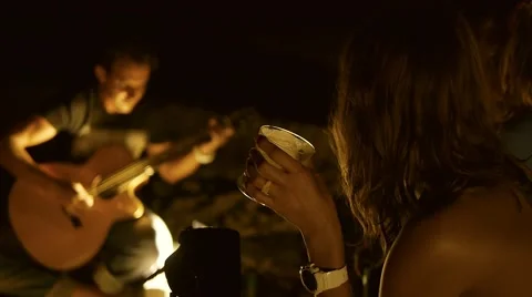 Spending time at campfire making barbecue and singing to a guitar. Slow motion. Stock Footage 56067607
