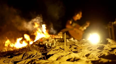 Spending time at campfire making barbecue and singing to a guitar.at night. Stock Footage 56067774