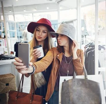 Spending the weekend in the shops. two young girlfriends snapping selfies while Stock Photos