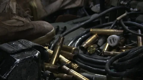 Spent ammunition cases falling inside armoured vehicle during live fire exercise Video stock 91211424