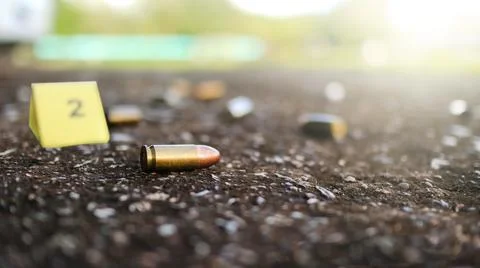 Spent bullet casing lying on dark ground with blur number 2 sign. Concepts .. Foto stock
