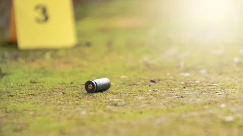 Spent bullet casing lying on the ground with blur number 3 sign. Concepts o.. Stock Photos