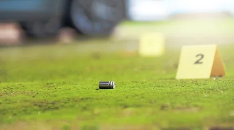 Spent bullet casing lying on the ground with blur number 2 sign. Concepts o.. Stock Photos