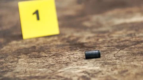 Spent bullet casing lying on the ground with blur number 1 sign. Concepts o.. Stock Photos
