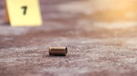 Spent bullet casing lying on the ground with blur number 7 sign. Concepts o.. Stock Photos