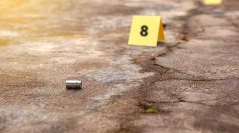 Spent bullet casing lying on the ground with blur number 8 sign. Concepts o.. Stock Photos
