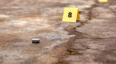 Spent bullet casing lying on the ground with blur number 8 sign. Concepts o.. Stock Photos
