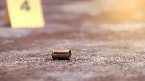 Spent bullet casing lying on the ground with blur number 4 sign. Concepts o.. Stock Photos