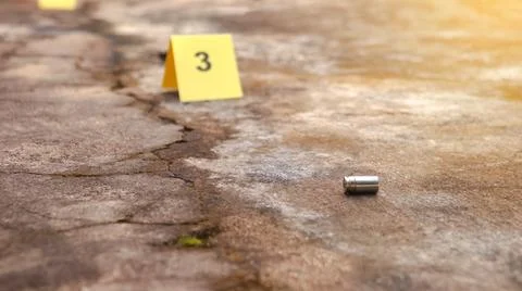 Spent bullet casing lying on the ground with blur number 3 sign. Concepts o.. Stock Photos