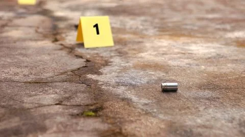 Spent bullet casing lying on the ground with blur number 1 sign. Concepts o.. Stock Photos
