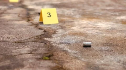 Spent bullet casing lying on the ground with blur number 3 sign. Concepts o.. Stock Photos