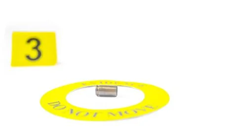 A spent bullet casing placed within a yellow circle, labeled with the text .. Stock Photos