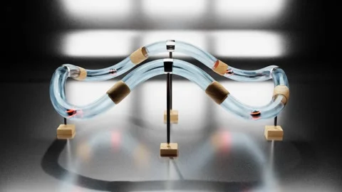 Spheres with luminous stripes roll inside a transparent glass tube on a metal st Stock Footage 255628244