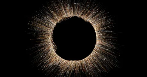 A spherical cluster of shimmering particles is constantly bubbling, emitting thi Stock-Footage 333867473