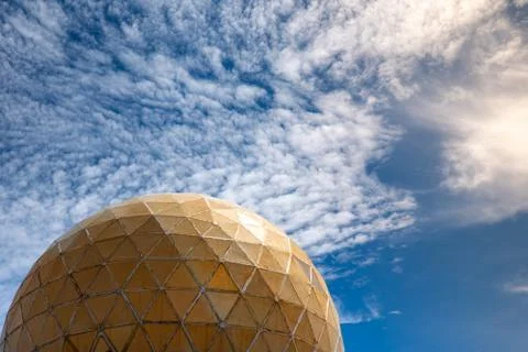 Spherical dome with close-up triangles against the cloudy blue sky. Stock Photos