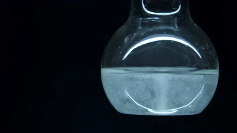 Spherical flask with liquid. Reaction in water. Stock Footage 238842931