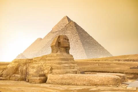 Sphinx and pyramids at sunset Stock Photos