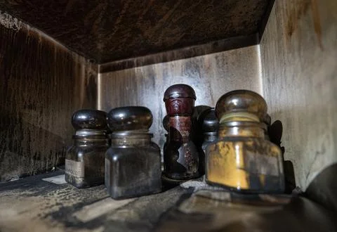Spice jars stored inside an old cabinet, covered with soot and grime Stock Photos