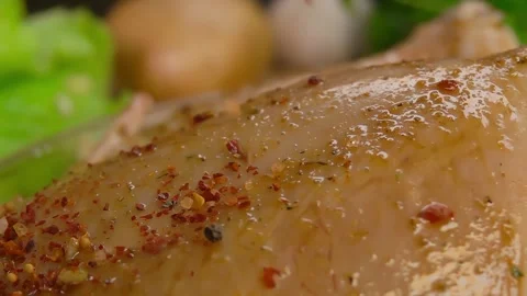 Spice mixture is sprinkled on chicken covered in sauce Stock Footage 294892800