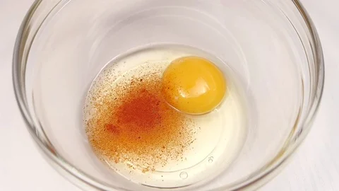 Spice pepper is added to plate with egg. Slow motion Stock Footage 76146252