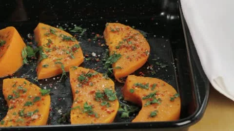 Spiced pumpkin wedges on a baking tray Stock Footage 24667505