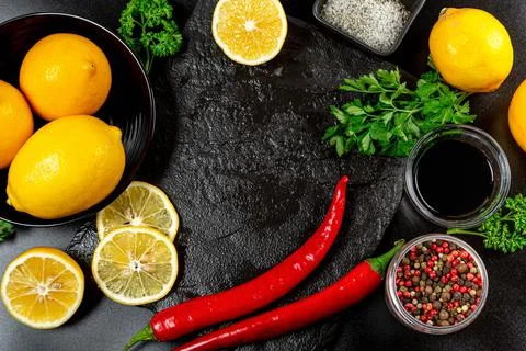 Spices and lemons on a dark background, top view Stock Photos