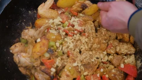 Spices are added to the dish in the cauldron. Shot of adding spices to a dish Stock Footage 280213816