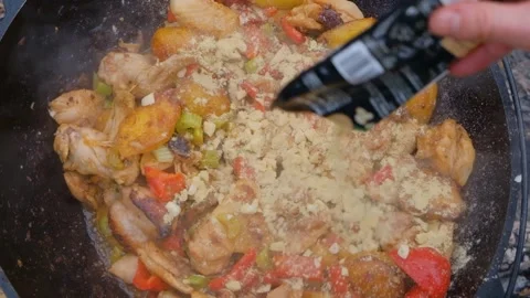 Spices are added to the dish in the cauldron. Shot of adding spices to a dish. S Stock Footage 282829796