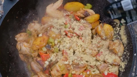 Spices are added to the dish in the cauldron. Shot of adding spices to a dish Stock Footage 307313955