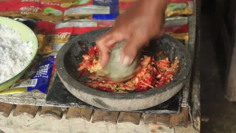 Spices are being ground using a stone pestle on a stone mortar Video stock 274732444