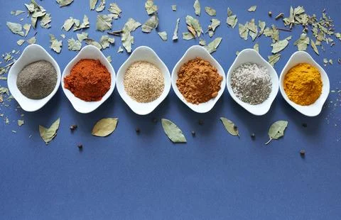 Spices close-up on blue background with laurel leaf. Stock Photos
