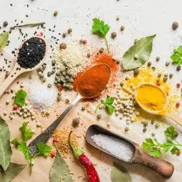 Spices in different spoons on a stone white background. A scattering of spice Stock Photos