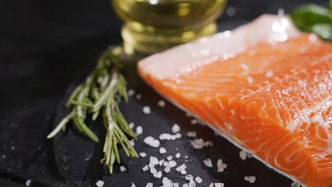 Spices fall on a raw salmon steak. Raw salmon red fish with pepper and salt. Stock Footage 116541621