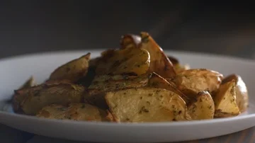 Spices Fall in Slow Motion on Plate of Roasted Potatoes Video stock 85533627
