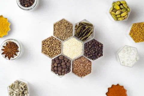 Spices in hexagonal jars on a white background Stock Photos