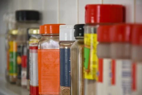 Spices lined up on a shelf Stock Photos
