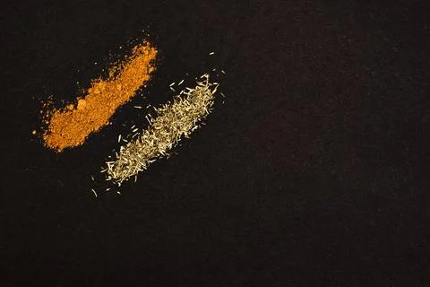 Spices scattered on a black background. Stock Photos