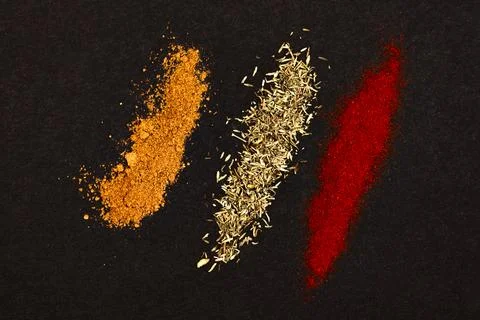 Spices scattered on a black background. Stock Photos