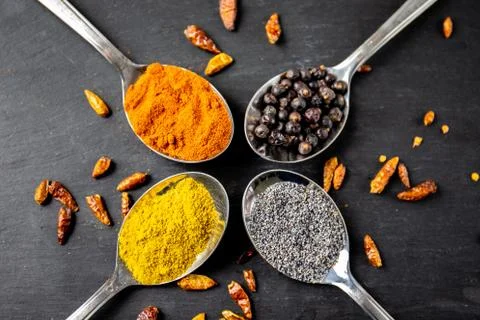 Spices. Spice in spoon. Herbs on stone table. chili pepper around the spoons Stock Photos