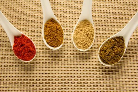 Spices in spoons on the table. Stock Photos