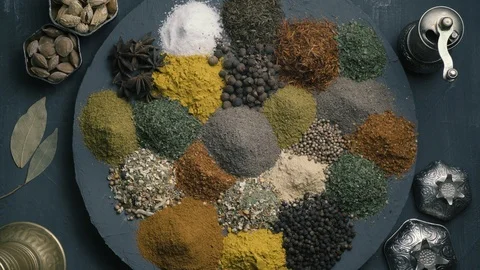 Spices in variety spin on a round surface on a dark background surrounded by Stock-Footage 123561145