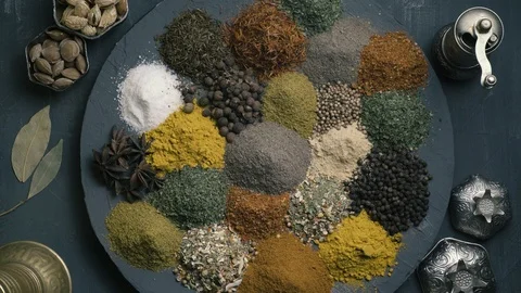 Spices in variety spin on a round surface on a dark background surrounded by Stock-Footage 123561322