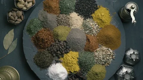 Spices in variety spin on a round surface on a dark background surrounded by Stock Footage 146938267
