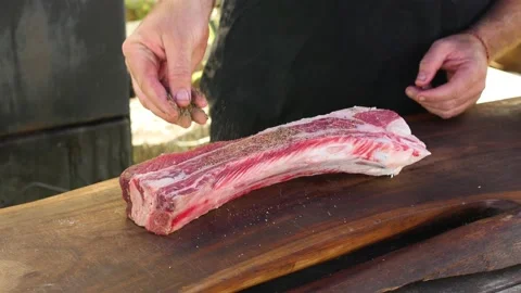 Spicing Asado meat with pepper Stock Footage 130935372