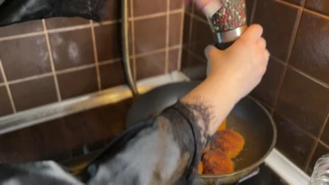Spicing golden cutlets while frying in oil on kitchen pan Stock Footage 310503401